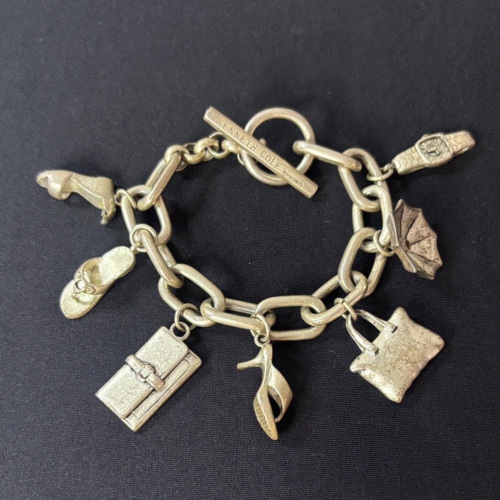 Kenneth Cole Silver-Tone Charm Bracelet with Iconic Charms (#0074).